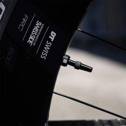 Dynamic Barkeeper Tubeless Valve asennettuna korkean profiilin tubeless-kiekkoon. Musta Presta-tubeless-venttiili gravel- ja maantiepyörään.