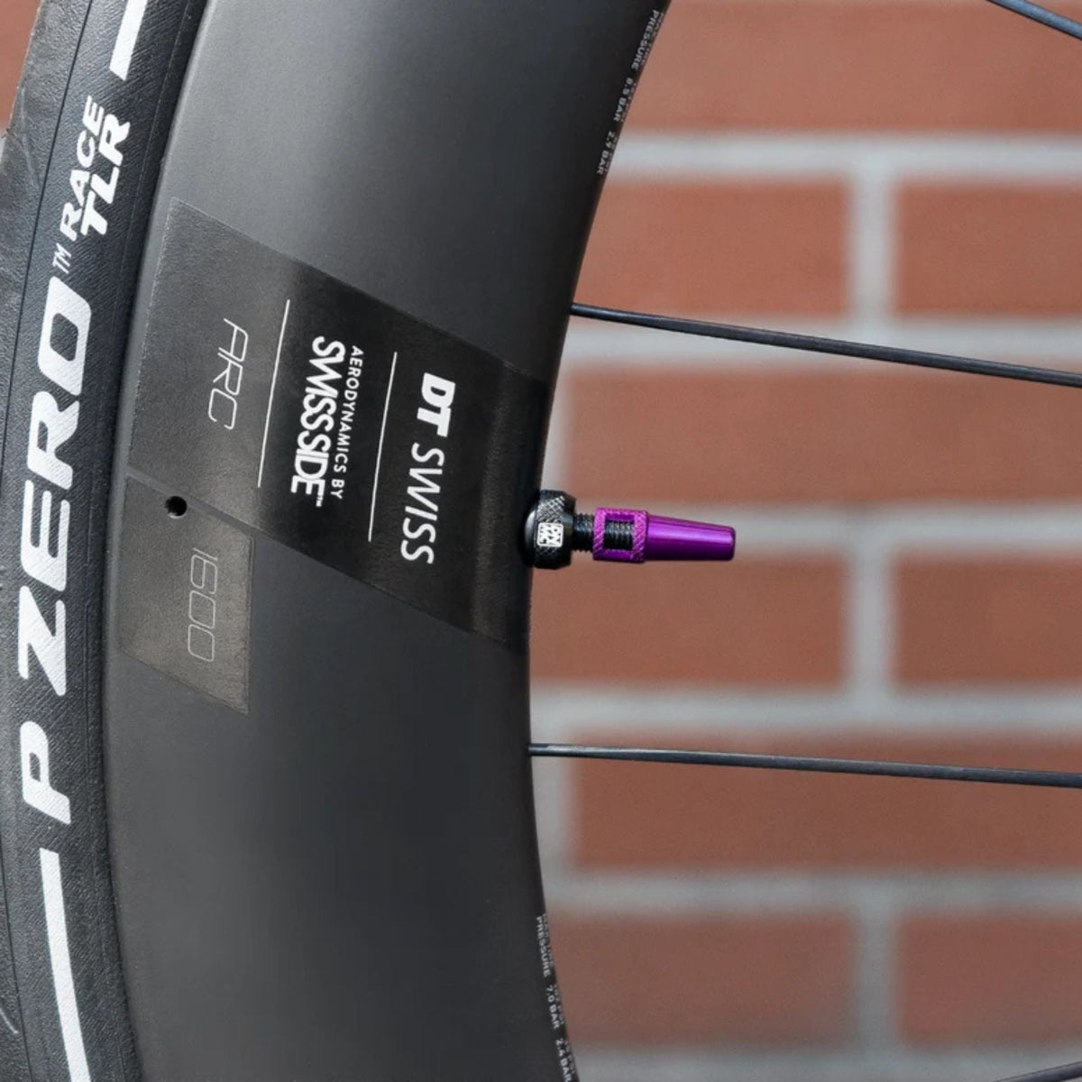 Dynamic Barkeeper Tubeless Valve violetti venttiilikorkki integroidulla venttiilisydäntyökalulla asennettuna hiilikuitukiekkoon.